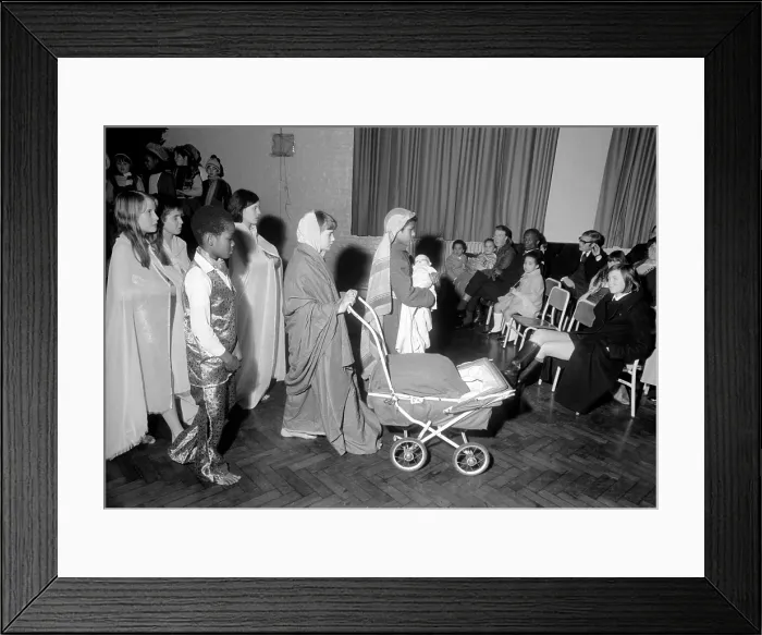 Framed Print : Nativity. A Hippie street singer, and Mary pushing a pram Framed Print : Nativity. A Hippie street singer, and Mary pushing a pram